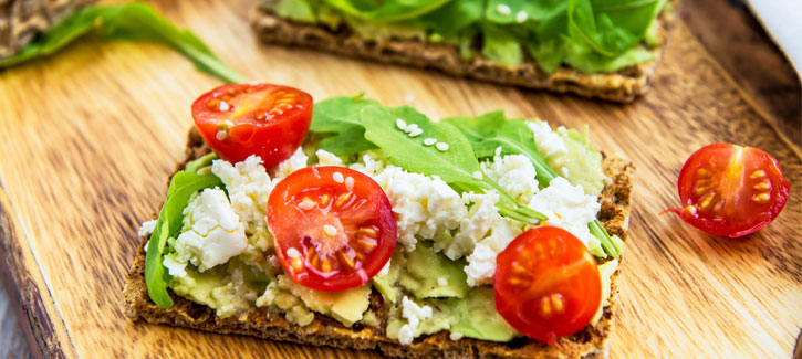 Crackers met avocado, geitenkaas en tomaatjes