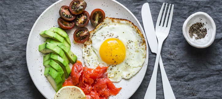 Gebakken ei met gerookte zalm, tomaatjes en avocado